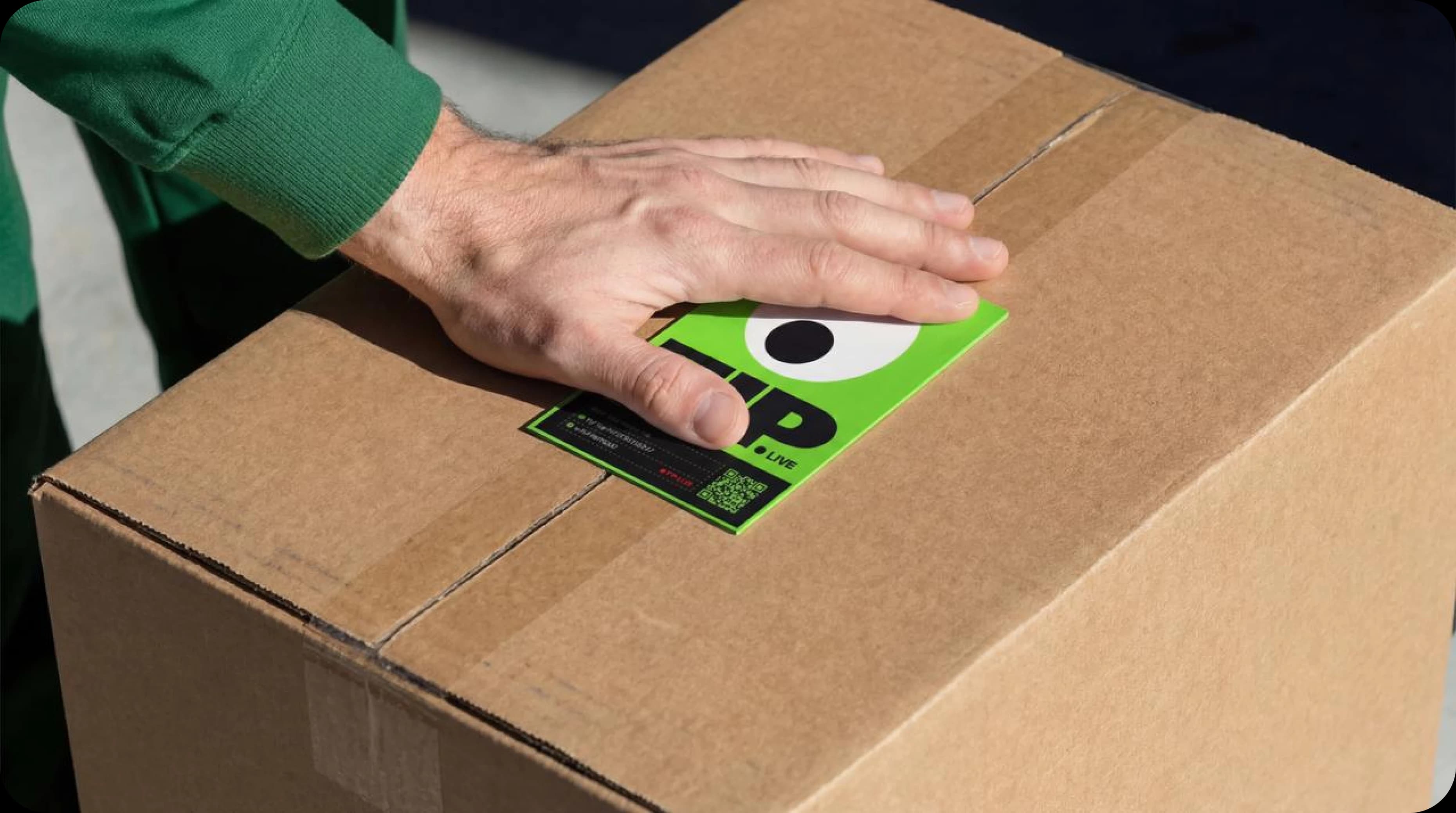 Hand placing a TIP tracking label on a shipment